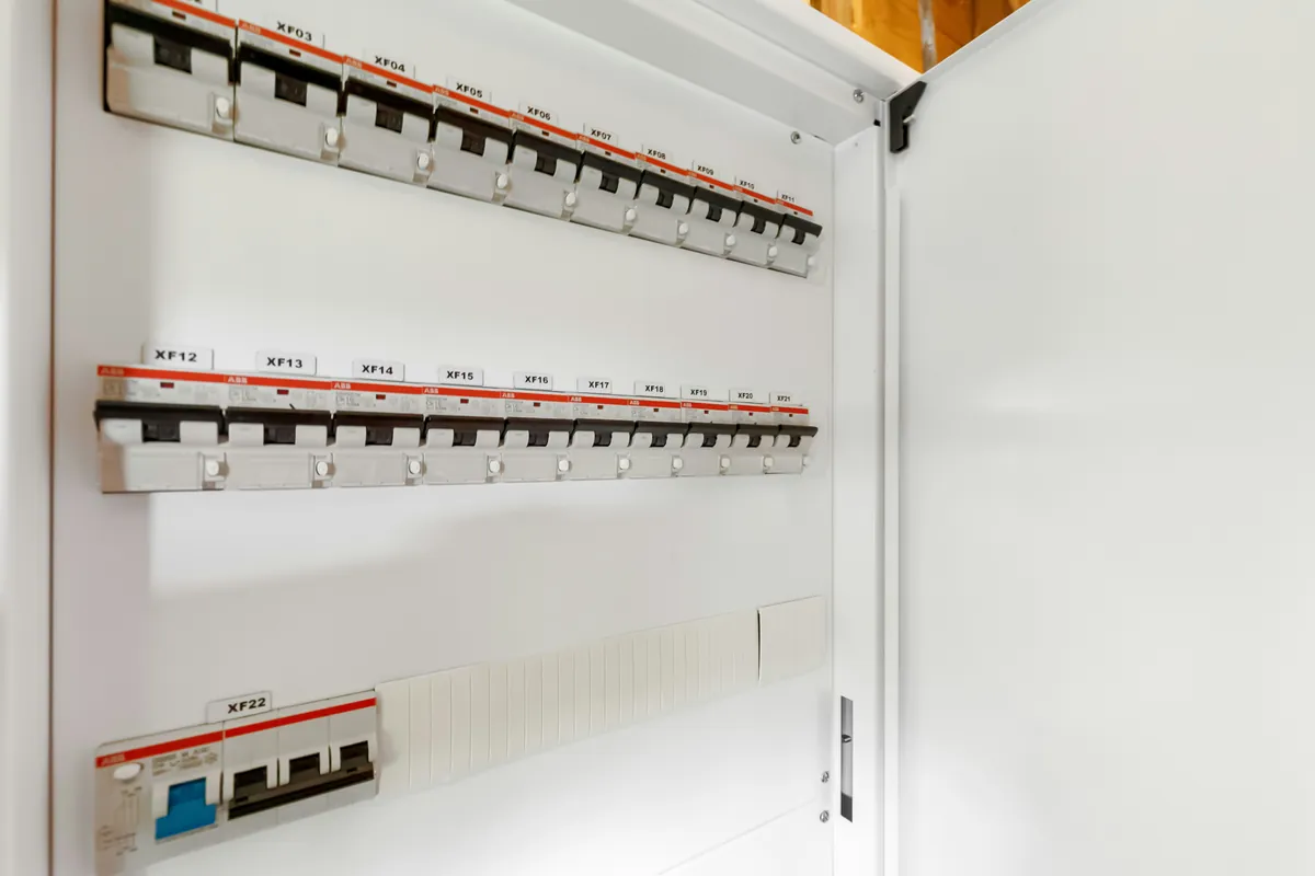 rows of DIN-rail breakers in an open white panel