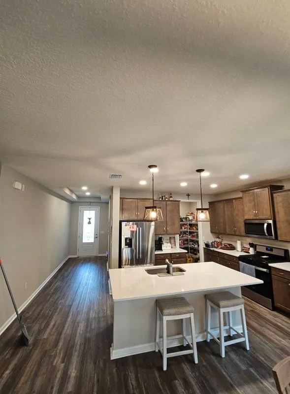 Bright open-plan kitchen with island and pendant lights
